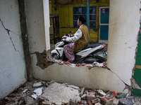 A motorcycle passes a collapsed wall after a 5.0 magnitude earthquake strikes in Kertasari, West Java, on September 18, 2024. At least 700 h...