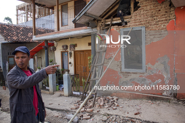 A man looks at his collapsed house after a 5.0 magnitude earthquake strikes in Kertasari, West Java, on September 18, 2024. At least 700 hou...