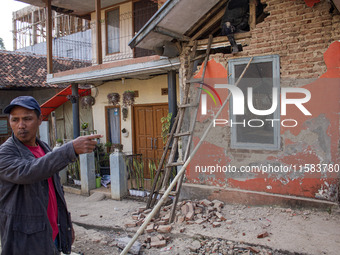 A man looks at his collapsed house after a 5.0 magnitude earthquake strikes in Kertasari, West Java, on September 18, 2024. At least 700 hou...