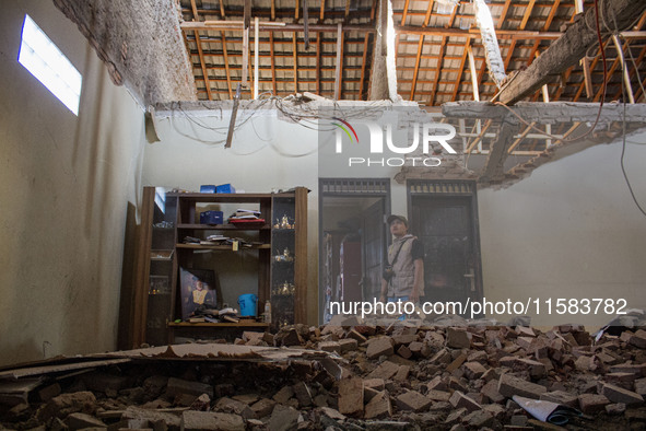 A man looks at his collapsed house after a 5.0 magnitude earthquake strikes in Kertasari, West Java, on September 18, 2024. At least 700 hou...