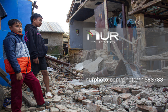 A child looks at his collapsed house after a 5.0 magnitude earthquake strikes in Kertasari, West Java, on September 18, 2024. At least 700 h...