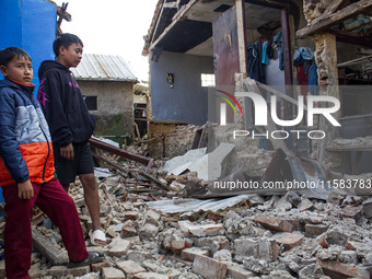 A child looks at his collapsed house after a 5.0 magnitude earthquake strikes in Kertasari, West Java, on September 18, 2024. At least 700 h...