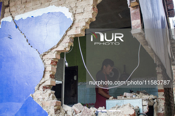 A man looks at his collapsed house after a 5.0 magnitude earthquake strikes in Kertasari, West Java, on September 18, 2024. At least 700 hou...