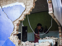 A man looks at his collapsed house after a 5.0 magnitude earthquake strikes in Kertasari, West Java, on September 18, 2024. At least 700 hou...