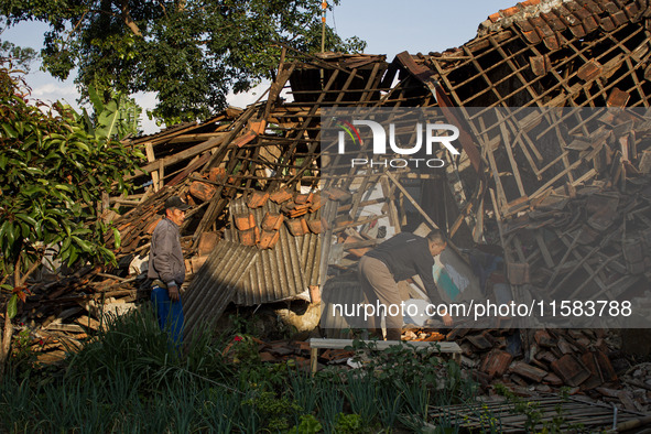 A man looks at his collapsed house after a 5.0 magnitude earthquake strikes in Kertasari, West Java, on September 18, 2024. At least 700 hou...