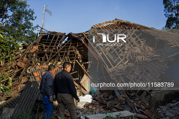 A man looks at his collapsed house after a 5.0 magnitude earthquake strikes in Kertasari, West Java, on September 18, 2024. At least 700 hou...