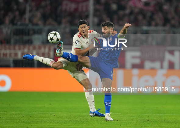 Minjae Kim of Bayern Munich and Bruno Petković of GNK Dinamo battle for the ball  during the Champions League Round 1 match between Bayern M...