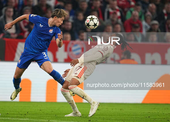 Michael Olise of Bayern Munich and Takuya Ogiwara of GNK Dinamo battle for the ball  during the Champions League Round 1 match between Bayer...