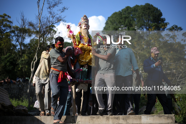 Devotees take the idol of Lord Vishwokarma to immerse it in a river on the outskirts of Kathmandu, Nepal, on September 18, 2024. Vishwokarma...