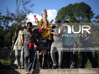 Devotees take the idol of Lord Vishwokarma to immerse it in a river on the outskirts of Kathmandu, Nepal, on September 18, 2024. Vishwokarma...