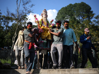 Devotees take the idol of Lord Vishwokarma to immerse it in a river on the outskirts of Kathmandu, Nepal, on September 18, 2024. Vishwokarma...