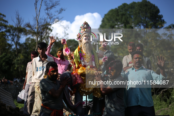 Devotees take the idol of Lord Vishwokarma to immerse it in a river on the outskirts of Kathmandu, Nepal, on September 18, 2024. Vishwokarma...