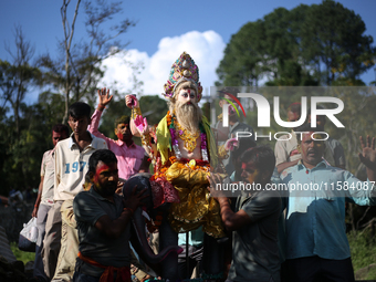 Devotees take the idol of Lord Vishwokarma to immerse it in a river on the outskirts of Kathmandu, Nepal, on September 18, 2024. Vishwokarma...