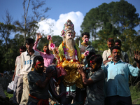 Devotees take the idol of Lord Vishwokarma to immerse it in a river on the outskirts of Kathmandu, Nepal, on September 18, 2024. Vishwokarma...