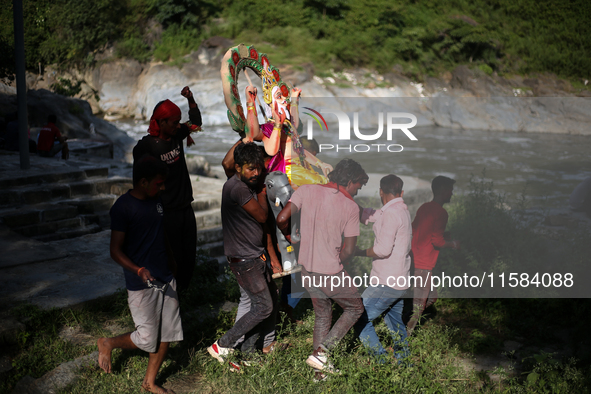 Devotees take the idol of Lord Vishwokarma to immerse it in a river on the outskirts of Kathmandu, Nepal, on September 18, 2024. Vishwokarma...