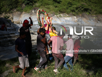 Devotees take the idol of Lord Vishwokarma to immerse it in a river on the outskirts of Kathmandu, Nepal, on September 18, 2024. Vishwokarma...