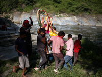 Devotees take the idol of Lord Vishwokarma to immerse it in a river on the outskirts of Kathmandu, Nepal, on September 18, 2024. Vishwokarma...