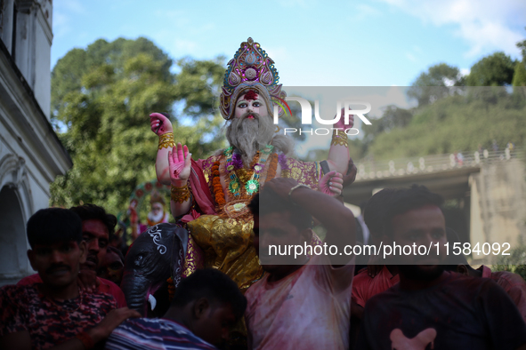 Devotees take the idol of Lord Vishwokarma to immerse it in a river on the outskirts of Kathmandu, Nepal, on September 18, 2024. Vishwokarma...