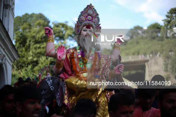 Devotees take the idol of Lord Vishwokarma to immerse it in a river on the outskirts of Kathmandu, Nepal, on September 18, 2024. Vishwokarma...