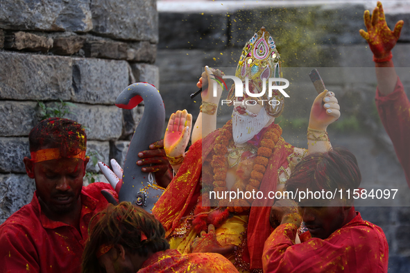 Devotees take the idol of Lord Vishwokarma to immerse it in a river on the outskirts of Kathmandu, Nepal, on September 18, 2024. Vishwokarma...