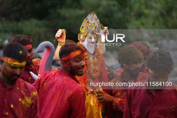 Devotees take the idol of Lord Vishwokarma to immerse it in a river on the outskirts of Kathmandu, Nepal, on September 18, 2024. Vishwokarma...