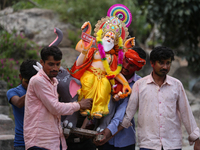 Devotees take the idol of Lord Vishwokarma to immerse it in a river on the outskirts of Kathmandu, Nepal, on September 18, 2024. Vishwokarma...