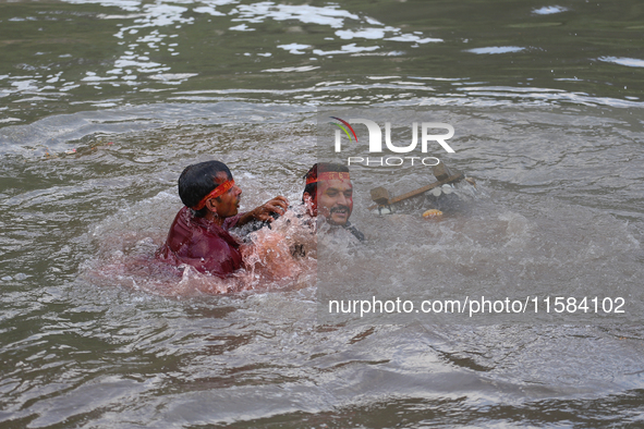 Hindu devotees immerse the idol of Vishwakarma, the god of machines and metallurgy, in the Bagmati River on the outskirts of Kathmandu, Nepa...