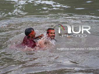 Hindu devotees immerse the idol of Vishwakarma, the god of machines and metallurgy, in the Bagmati River on the outskirts of Kathmandu, Nepa...