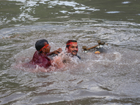 Hindu devotees immerse the idol of Vishwakarma, the god of machines and metallurgy, in the Bagmati River on the outskirts of Kathmandu, Nepa...