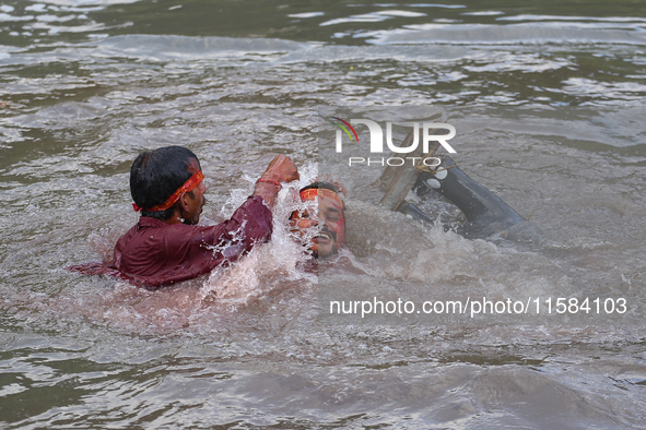 Hindu devotees immerse the idol of Vishwakarma, the god of machines and metallurgy, in the Bagmati River on the outskirts of Kathmandu, Nepa...