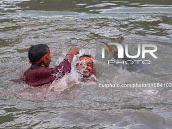 Hindu devotees immerse the idol of Vishwakarma, the god of machines and metallurgy, in the Bagmati River on the outskirts of Kathmandu, Nepa...