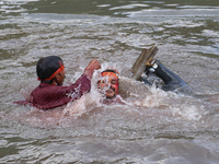 Hindu devotees immerse the idol of Vishwakarma, the god of machines and metallurgy, in the Bagmati River on the outskirts of Kathmandu, Nepa...