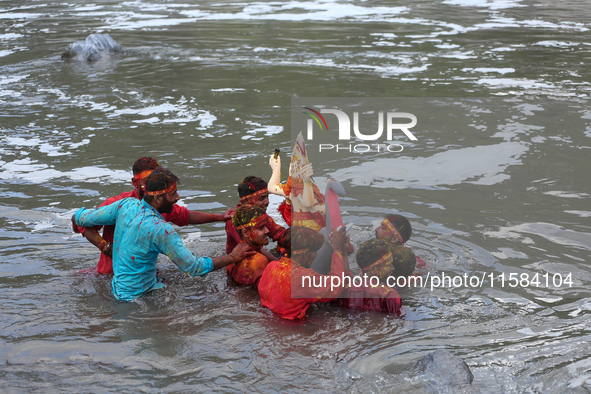 Hindu devotees immerse the idol of Vishwakarma, the god of machines and metallurgy, in the Bagmati River on the outskirts of Kathmandu, Nepa...