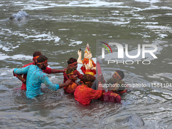 Hindu devotees immerse the idol of Vishwakarma, the god of machines and metallurgy, in the Bagmati River on the outskirts of Kathmandu, Nepa...