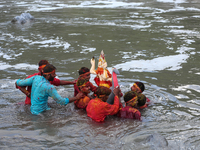 Hindu devotees immerse the idol of Vishwakarma, the god of machines and metallurgy, in the Bagmati River on the outskirts of Kathmandu, Nepa...