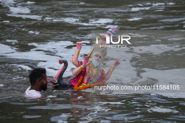 Hindu devotees immerse the idol of Vishwakarma, the god of machines and metallurgy, in the Bagmati River on the outskirts of Kathmandu, Nepa...