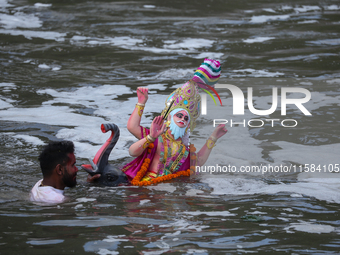 Hindu devotees immerse the idol of Vishwakarma, the god of machines and metallurgy, in the Bagmati River on the outskirts of Kathmandu, Nepa...