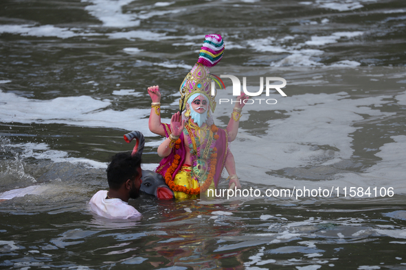 Hindu devotees immerse the idol of Vishwakarma, the god of machines and metallurgy, in the Bagmati River on the outskirts of Kathmandu, Nepa...