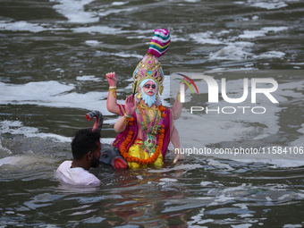 Hindu devotees immerse the idol of Vishwakarma, the god of machines and metallurgy, in the Bagmati River on the outskirts of Kathmandu, Nepa...