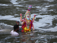 Hindu devotees immerse the idol of Vishwakarma, the god of machines and metallurgy, in the Bagmati River on the outskirts of Kathmandu, Nepa...