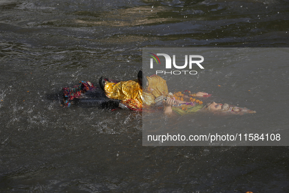 Hindu devotees immerse the idol of Vishwakarma, the god of machines and metallurgy, in the Bagmati River on the outskirts of Kathmandu, Nepa...