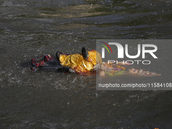 Hindu devotees immerse the idol of Vishwakarma, the god of machines and metallurgy, in the Bagmati River on the outskirts of Kathmandu, Nepa...