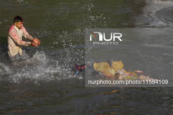 Hindu devotees immerse the idol of Vishwakarma, the god of machines and metallurgy, in the Bagmati River on the outskirts of Kathmandu, Nepa...