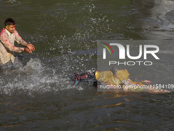 Hindu devotees immerse the idol of Vishwakarma, the god of machines and metallurgy, in the Bagmati River on the outskirts of Kathmandu, Nepa...