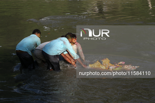 Hindu devotees immerse the idol of Vishwakarma, the god of machines and metallurgy, in the Bagmati River on the outskirts of Kathmandu, Nepa...