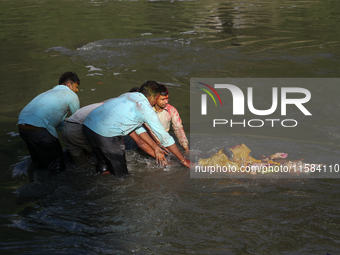 Hindu devotees immerse the idol of Vishwakarma, the god of machines and metallurgy, in the Bagmati River on the outskirts of Kathmandu, Nepa...