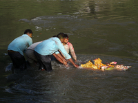 Hindu devotees immerse the idol of Vishwakarma, the god of machines and metallurgy, in the Bagmati River on the outskirts of Kathmandu, Nepa...