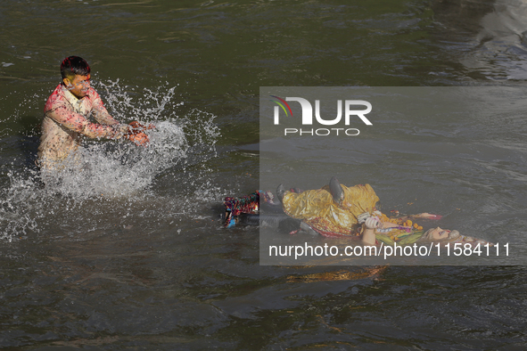 Hindu devotees immerse the idol of Vishwakarma, the god of machines and metallurgy, in the Bagmati River on the outskirts of Kathmandu, Nepa...