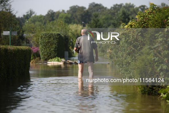 A man walks through floodwaters in the social gardens on the outskirts of Wroclaw, Poland, on September 18, 2024. The government outlines a...