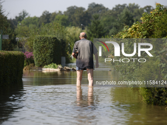 A man walks through floodwaters in the social gardens on the outskirts of Wroclaw, Poland, on September 18, 2024. The government outlines a...